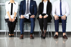Group of candidates holding resumes, highlighting the importance of rethinking recruitment sourcing.